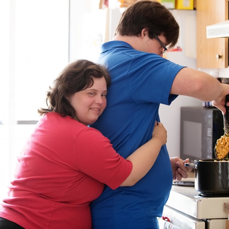 Un couple de personnes atteintes du syndrome de Down fait la cuisine ensemble. 