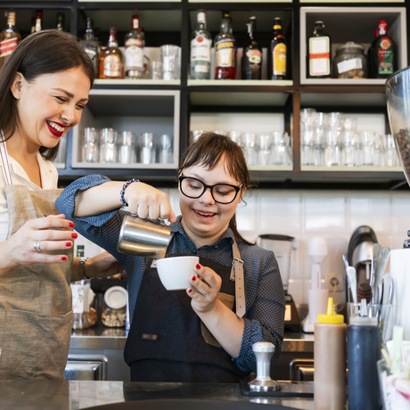 Une jeune femme atteinte du syndrome de Down travaille dans un café.