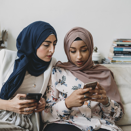 Deux femmes regardent leur téléphone.
